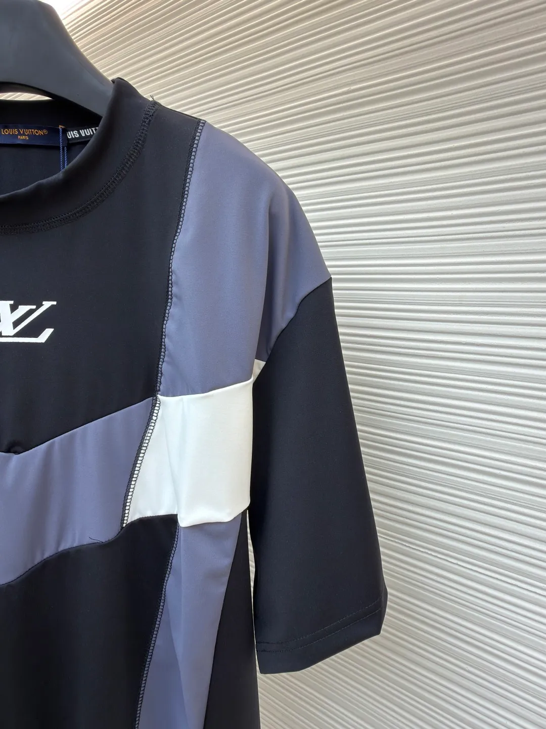 LOUIS VUITTON Spliced round neck jogging short-sleeved T-shirt ●Original version: purchased and developed by 8167 ●Item number: 1682020-A20 ●Fabric: cotton fabric ●Technology: made on positioning cutting machine ●Color: black, gray and white ●Type: fitted version ●Weight: about 295 grams ●Size: S-M-L-XL ●Description: This LOUIS VUITTON The FW25 jogging short-sleeved T-shirt is made of high-elastic technical knitted fabric (presumably a blend of polyester fiber and spandex). It has been treated with directional stretching technology and has both breathability and sports extensibility. The body of the garment adopts color-blocking insert technology: black, gray, and white panels are spliced ​​diagonally in a V-shape, and the edges are processed with "boneless overlocking" to make the seams smooth and smooth. The "LV" logo on the chest uses a silicone embossing + embroidery composite process: first outline the outline with embroidery thread of the same color, and then cover it with a matte silicone layer, which not only ensures the three-dimensionality of the logo, but also prevents it from falling off after washing. The neckline is double-layered ribbed and has built-in elastic webbing for reinforcement, making it less likely to deform after long-term wear. The overall shape is sporty and slim-fitting, and the arc of the cut piece has been ergonomically optimized, making it suitable for light sports such as jogging. The overall wiring is straight and delicate, the fabric is comfortable and soft, and the color is consistent without color difference. It can be matched with the same style to create a fashionable look and control various occasions. Customized accessories, complete with three standards, same style for men and women!